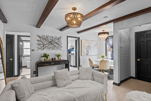 living area featuring a chandelier, beamed ceiling, and baseboards