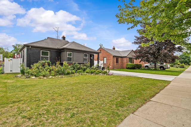 view of front of house with brick siding, a chimney, and concrete driveway