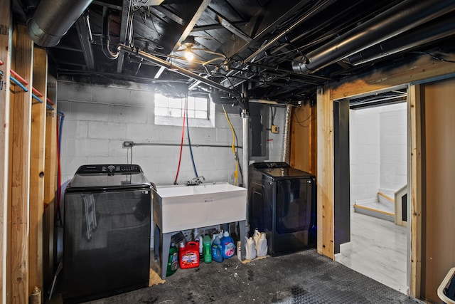 basement with a sink, stairs, and washer and dryer