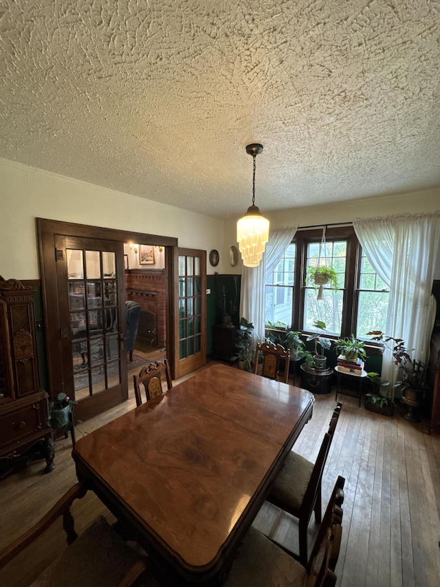 701 Chestnut St, Grayling, MI 49738 - dining room with a textured ceiling, a chandelier, hardwood / wood-style flooring, and french doors