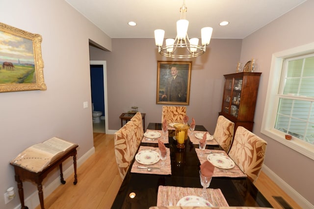 722 Bennington St, East Tawas, MI 48730 - dining area featuring a chandelier, wood finished floors, baseboards, and recessed lighting