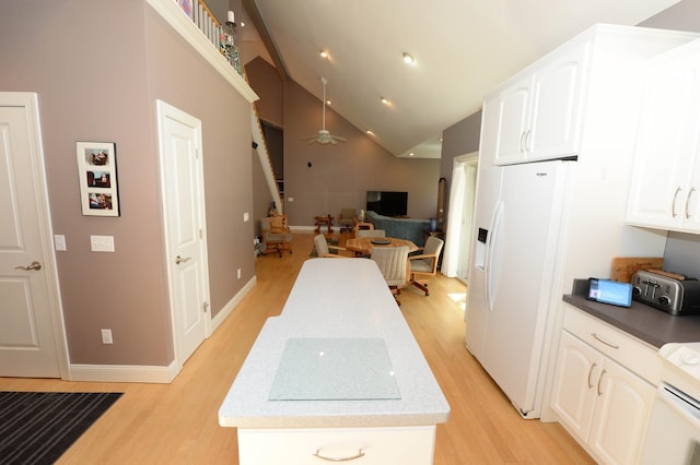 722 Bennington St, East Tawas, MI 48730 - kitchen with white appliances, light wood-style flooring, white cabinets, high vaulted ceiling, and open floor plan