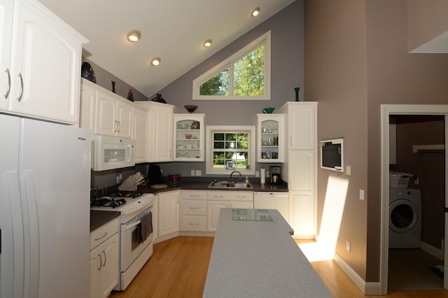 722 Bennington St, East Tawas, MI 48730 - kitchen with white appliances, washer / dryer, a sink, glass insert cabinets, and light wood-style flooring