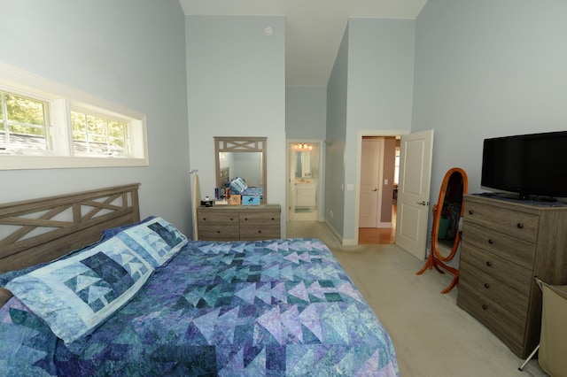722 Bennington St, East Tawas, MI 48730 - bedroom featuring high vaulted ceiling, light colored carpet, connected bathroom, and baseboards
