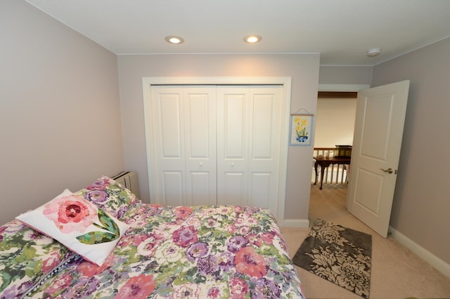 722 Bennington St, East Tawas, MI 48730 - bedroom with radiator, light colored carpet, a closet, recessed lighting, and baseboards