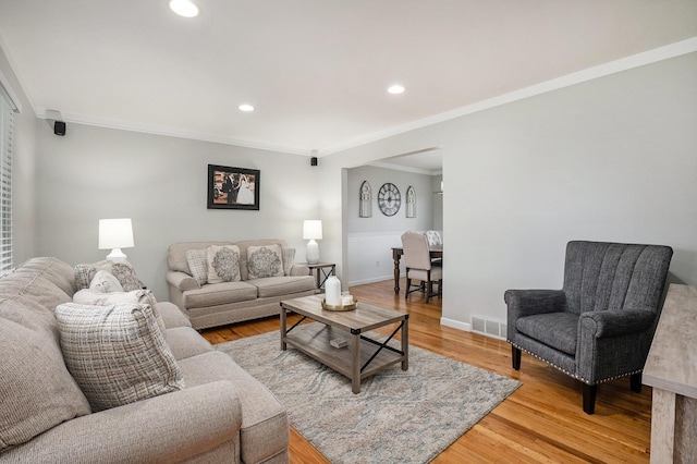 living room with light wood-style flooring, ornamental molding, recessed lighting, and baseboards