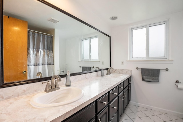 full bathroom featuring tile patterned flooring, baseboards, and double vanity