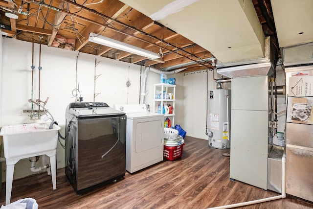 laundry area with water heater, wood finished floors, independent washer and dryer, and heating unit
