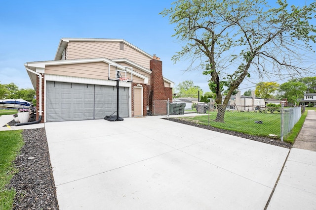 view of front facade with driveway, an attached garage, a gate, brick siding, and a chimney