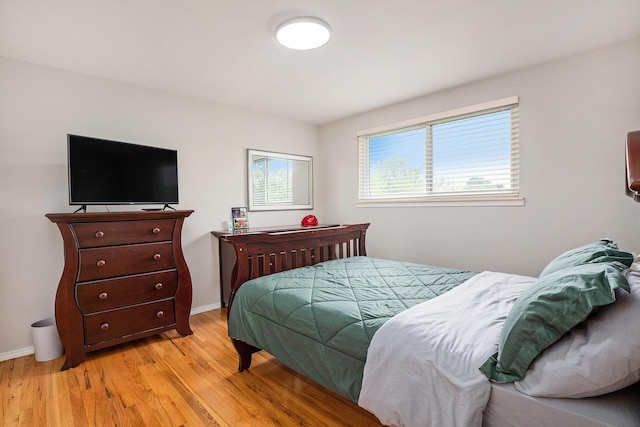 bedroom with light wood-type flooring and baseboards
