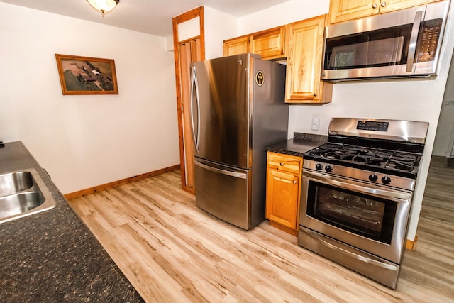 789 W Castle Rd, Fostoria, MI 48435 - kitchen featuring stainless steel appliances, light wood-style floors, a sink, and baseboards