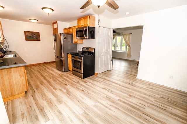 789 W Castle Rd, Fostoria, MI 48435 - kitchen featuring stainless steel appliances, ceiling fan, baseboards, light wood-type flooring, and a sink