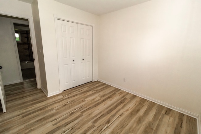 789 W Castle Rd, Fostoria, MI 48435 - unfurnished bedroom featuring wood finished floors, a closet, and baseboards