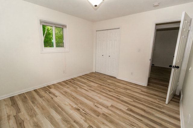 789 W Castle Rd, Fostoria, MI 48435 - unfurnished bedroom featuring light wood-style floors, a closet, and baseboards