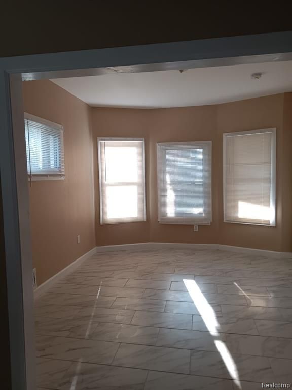 8879 N Clarendon St, Detroit, MI 48204 - unfurnished room featuring marble finish flooring and baseboards