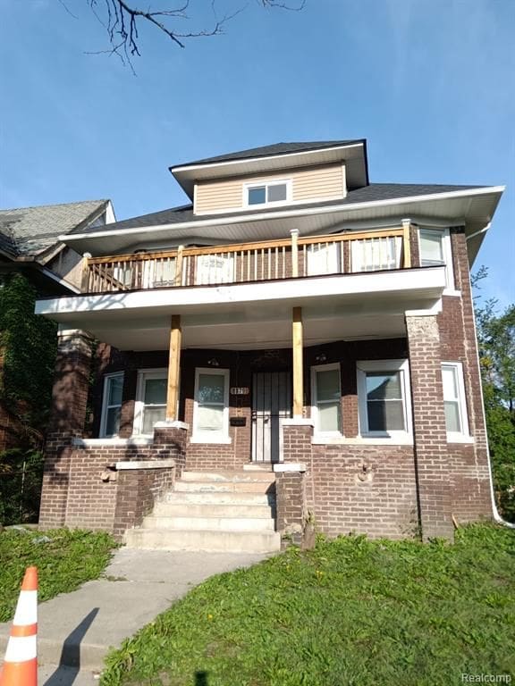 8879 N Clarendon St, Detroit, MI 48204 - view of front of house featuring a balcony, a porch, and brick siding