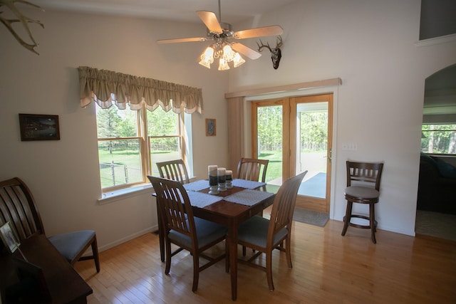 1820 Elk Ct, Owosso, MI 48867 - dining space featuring ceiling fan, light wood-style floors, a towering ceiling, baseboards, and arched walkways