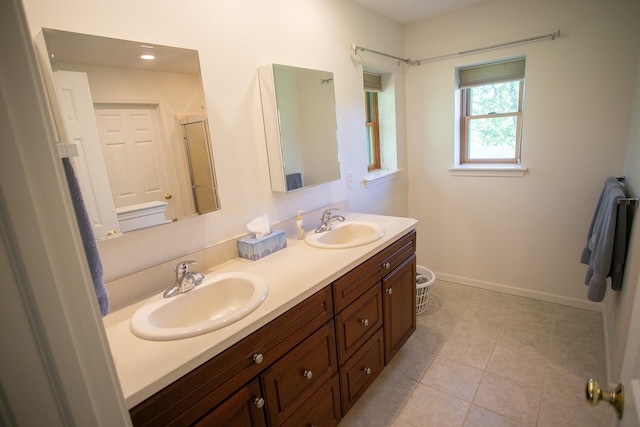 1820 Elk Ct, Owosso, MI 48867 - bathroom with double vanity, baseboards, and tile patterned floors