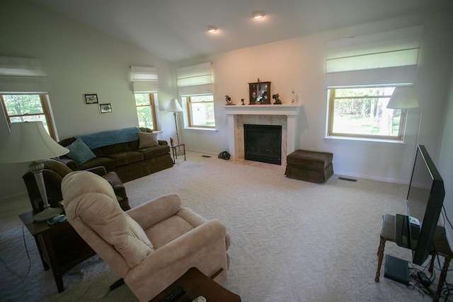 1820 Elk Ct, Owosso, MI 48867 - carpeted living room with a tiled fireplace, healthy amount of natural light, vaulted ceiling, and baseboards