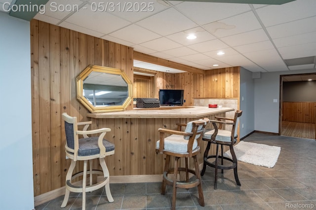 42739 Pond View Dr, Sterling Heights, MI 48314 - kitchen featuring wood walls, baseboards, a drop ceiling, recessed lighting, and a kitchen breakfast bar