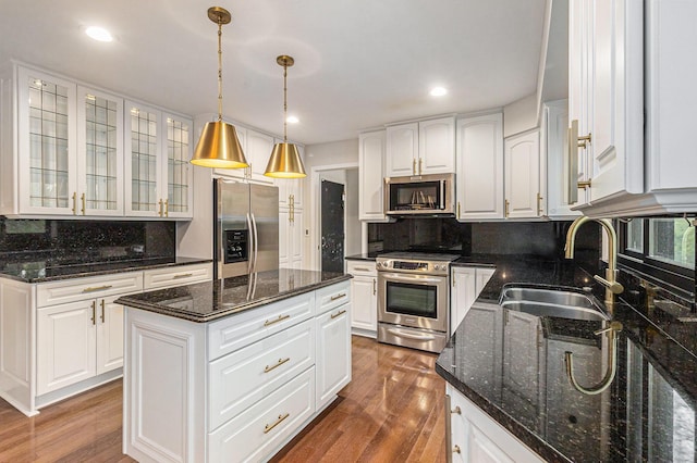 2315 Adare Rd, Ann Arbor, MI 48104 - kitchen featuring appliances with stainless steel finishes, a sink, glass insert cabinets, wood finished floors, and recessed lighting