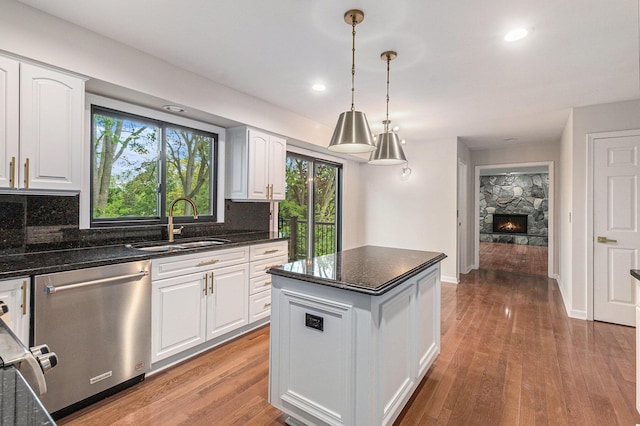 2315 Adare Rd, Ann Arbor, MI 48104 - kitchen featuring a sink, stainless steel dishwasher, decorative backsplash, white cabinets, and a center island