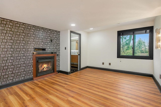 2315 Adare Rd, Ann Arbor, MI 48104 - unfurnished living room with wood finished floors, recessed lighting, a glass covered fireplace, and baseboards