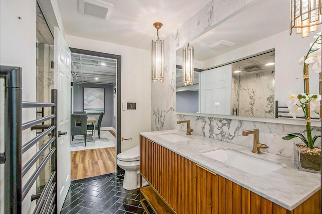 2315 Adare Rd, Ann Arbor, MI 48104 - bathroom with toilet, double vanity, and decorative backsplash
