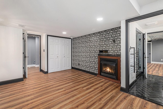 2315 Adare Rd, Ann Arbor, MI 48104 - unfurnished living room with wood finished floors, baseboards, a glass covered fireplace, and recessed lighting