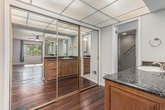 2315 Adare Rd, Ann Arbor, MI 48104 - bathroom with wood finished floors, a ceiling fan, a tile shower, vanity, and baseboards