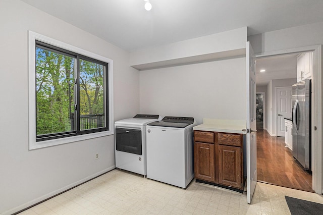 2315 Adare Rd, Ann Arbor, MI 48104 - clothes washing area with independent washer and dryer, light flooring, cabinet space, and baseboards