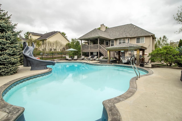 5221 Whittaker Trl, Linden, MI 48451 - view of pool with stairs, fence, a patio area, a water slide, and a deck