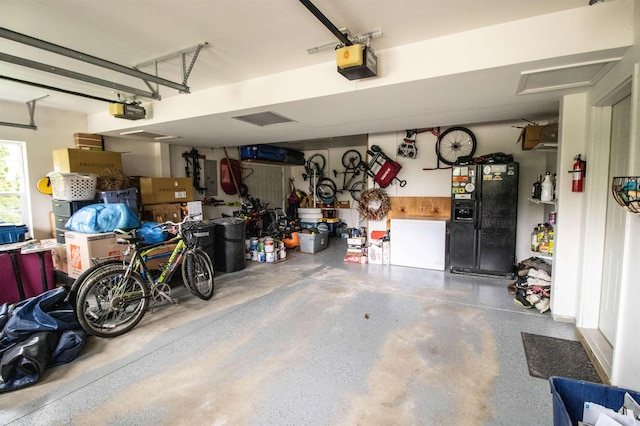 5221 Whittaker Trl, Linden, MI 48451 - garage with black refrigerator with ice dispenser and a garage door opener
