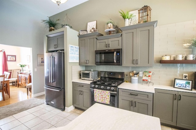 5221 Whittaker Trl, Linden, MI 48451 - kitchen featuring stainless steel appliances, gray cabinetry, tasteful backsplash, and light countertops