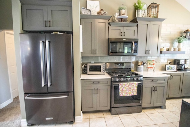 5221 Whittaker Trl, Linden, MI 48451 - kitchen with stainless steel appliances, gray cabinetry, tasteful backsplash, light countertops, and open shelves