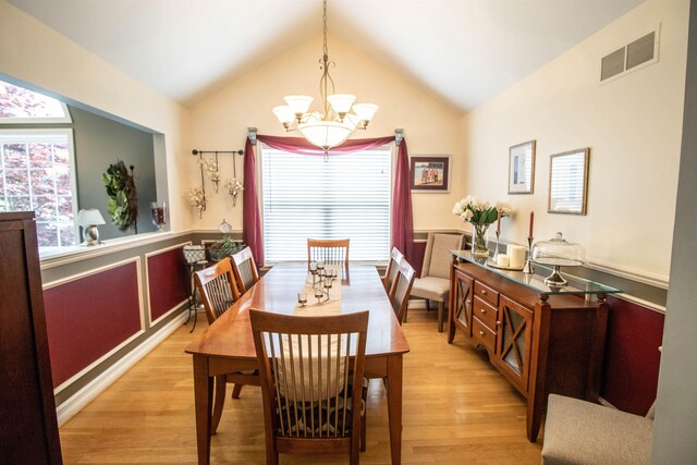 5221 Whittaker Trl, Linden, MI 48451 - dining area featuring a chandelier, light wood-style floors, healthy amount of natural light, vaulted ceiling, and a wainscoted wall