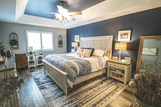 5221 Whittaker Trl, Linden, MI 48451 - bedroom featuring wood finished floors, a tray ceiling, and a ceiling fan