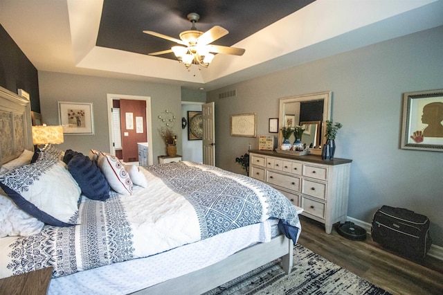 5221 Whittaker Trl, Linden, MI 48451 - bedroom featuring dark wood-style floors, baseboards, a tray ceiling, and a ceiling fan
