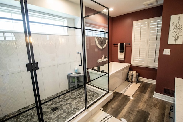 5221 Whittaker Trl, Linden, MI 48451 - bathroom with wood finished floors, a soaking tub, a shower stall, and baseboards