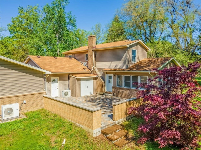 7045 Crane Rd, Ypsilanti, MI 48197 - rear view of property featuring ac unit, a chimney, a garage, and brick siding