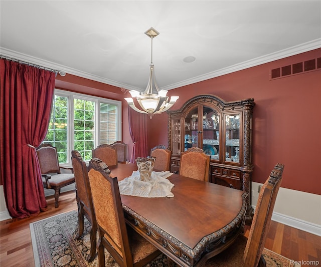 17747 Parkshore Dr, Northville, MI 48168 - dining room featuring a chandelier, wood finished floors, ornamental molding, and baseboards