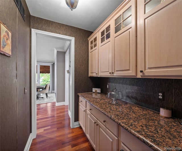 17747 Parkshore Dr, Northville, MI 48168 - kitchen with dark wood-style floors, glass insert cabinets, baseboards, crown molding, and dark stone counters
