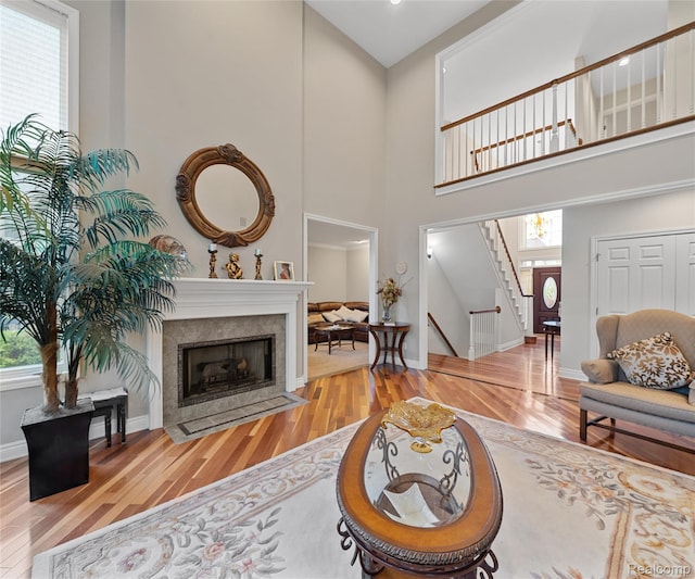 17747 Parkshore Dr, Northville, MI 48168 - living area featuring plenty of natural light, wood finished floors, stairway, a high ceiling, and a tile fireplace