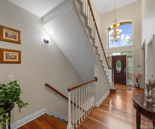 17747 Parkshore Dr, Northville, MI 48168 - foyer featuring a chandelier, wood finished floors, stairway, a towering ceiling, and baseboards