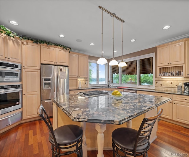 17747 Parkshore Dr, Northville, MI 48168 - kitchen featuring stainless steel appliances, a warming drawer, light brown cabinetry, a kitchen bar, and tasteful backsplash