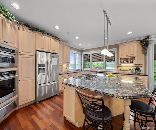 17747 Parkshore Dr, Northville, MI 48168 - kitchen featuring appliances with stainless steel finishes, a warming drawer, light brown cabinets, a kitchen bar, and ornamental molding
