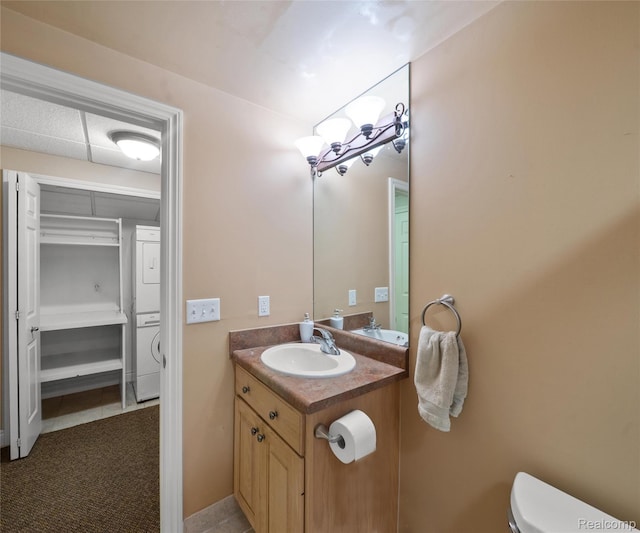 17747 Parkshore Dr, Northville, MI 48168 - half bathroom with estacked washer and dryer, vanity, toilet, and tile patterned floors
