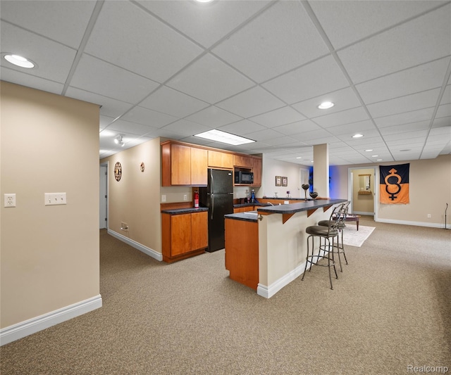 17747 Parkshore Dr, Northville, MI 48168 - kitchen featuring black appliances, light colored carpet, a kitchen bar, dark countertops, and recessed lighting