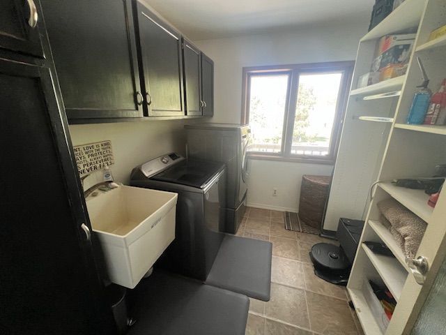 6600 Park Valley Dr, Clarkston, MI 48348 - washroom with cabinet space, washer and dryer, and light tile patterned floors