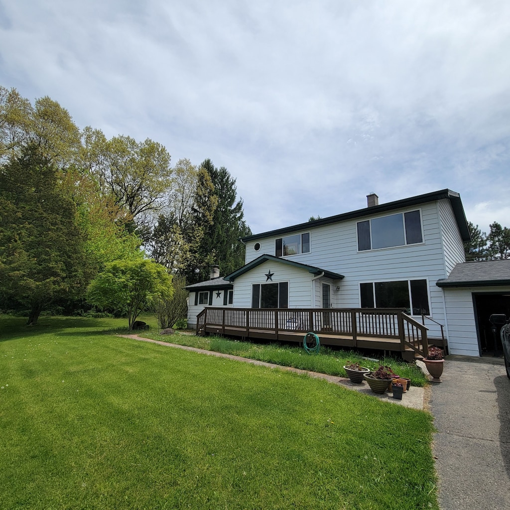 400 E Schafer Rd, Pinckney, MI 48169 - view of front of home featuring a deck, a front yard, and asphalt driveway